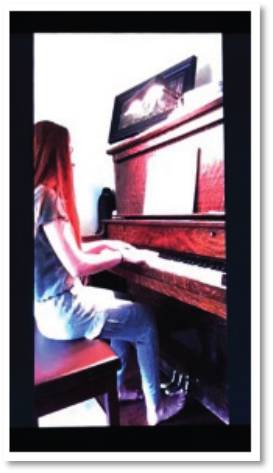 Example of a cameras POV during an exam, showing a young woman playing a piano