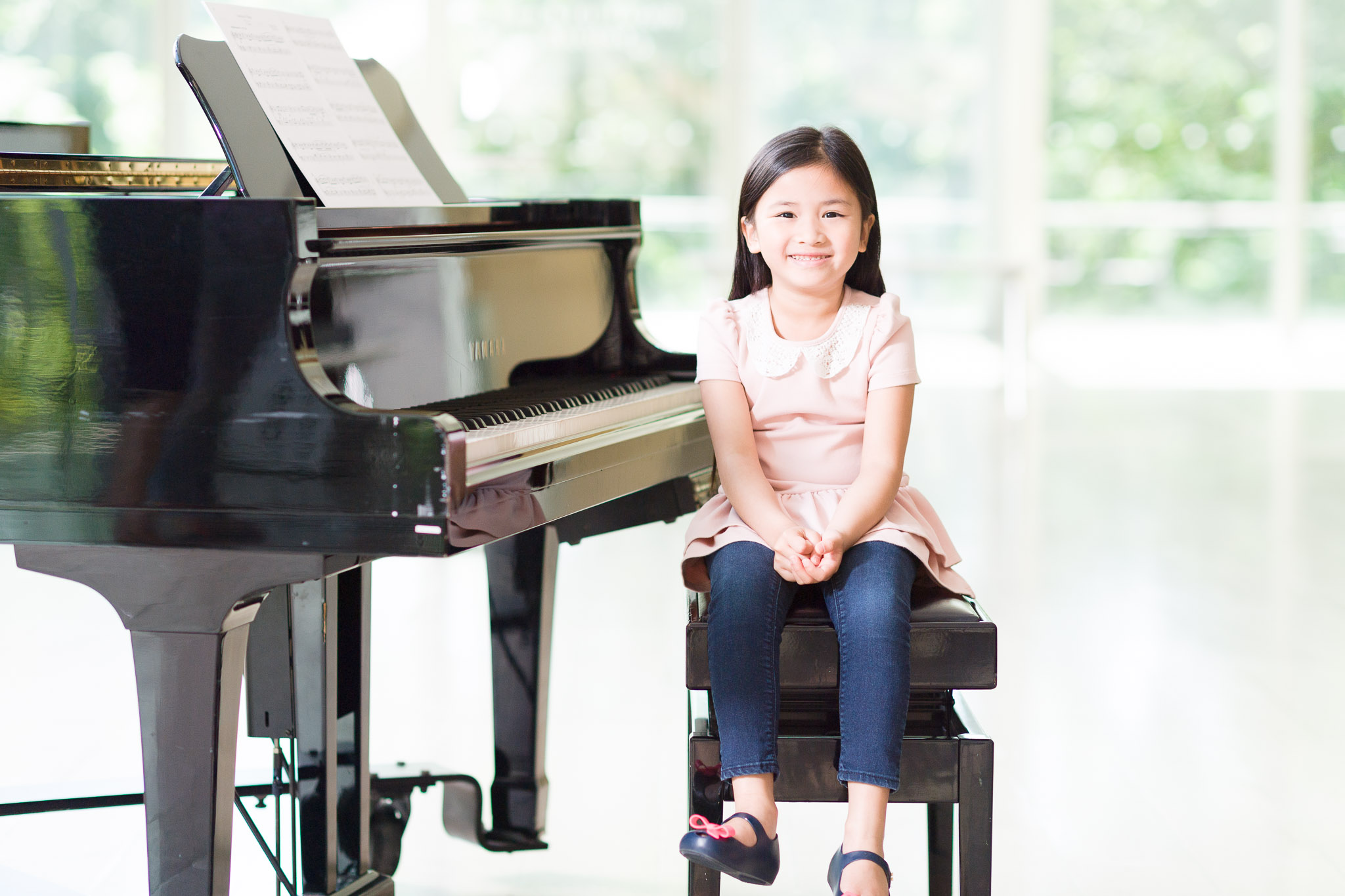 Young girl sitting by a piano